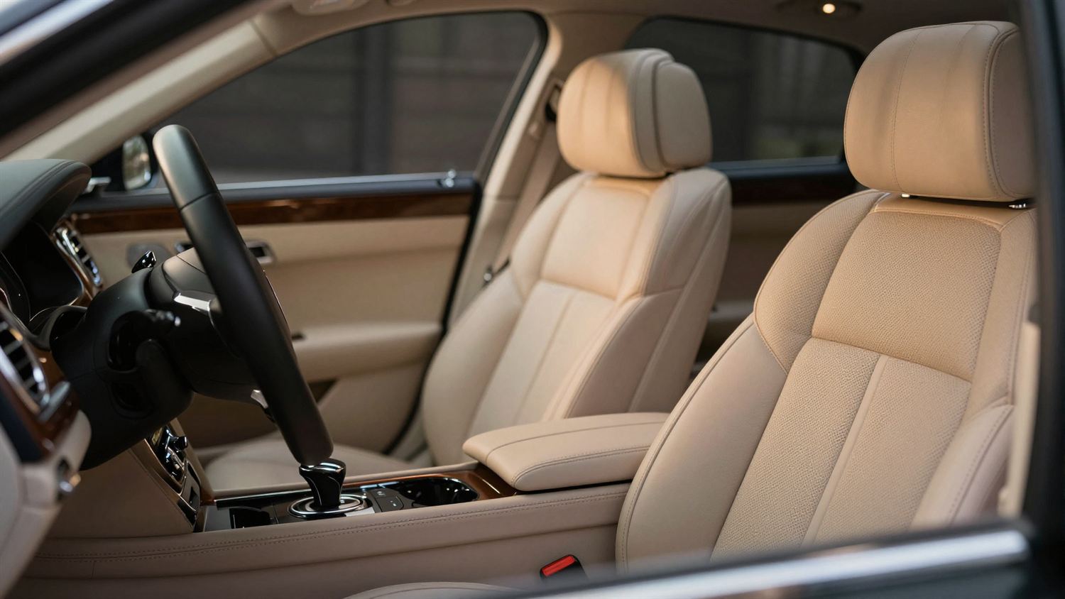 A detailed car interior, steering wheel and stitched leather